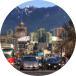 Cars driving through Barrie, Canada, with the city and mountains in the background.