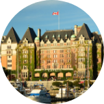 Grand building in Victoria, Canada, with greenery growing up the building and a Canadian flag flying on top.