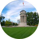 Temple-style tower in Waterloo, Canada, featuring a clock face and flag flying at the top.