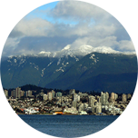 City in Canada at the foot of a mountain with water in front.