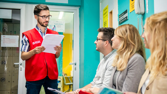 A teacher is handing on the IELTS exam to the students