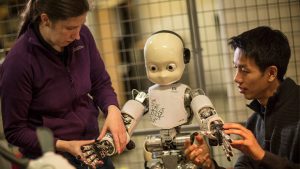 Two people are working with a robot