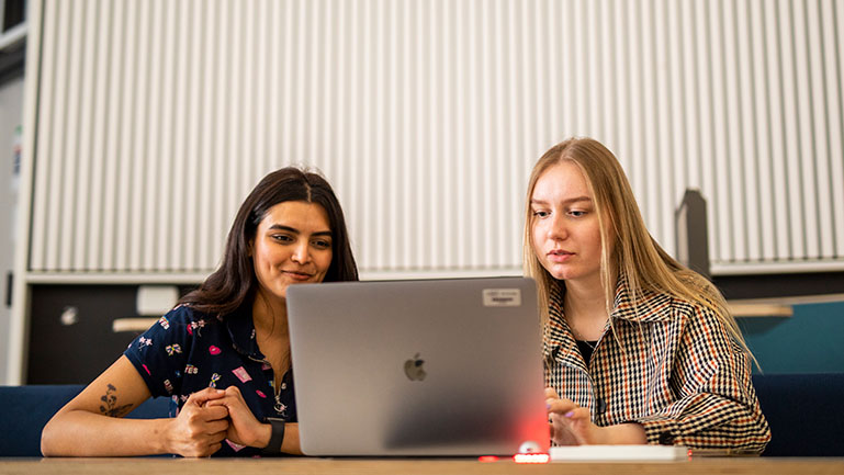 Two women studying together to take the IELTS